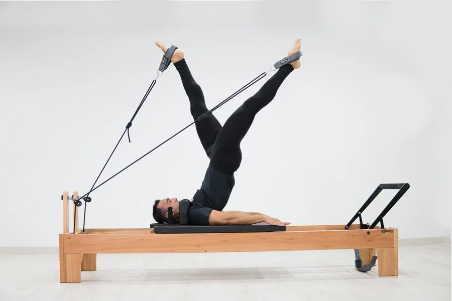 Practicando ejercicio físico y pilates hombre sobre máquina