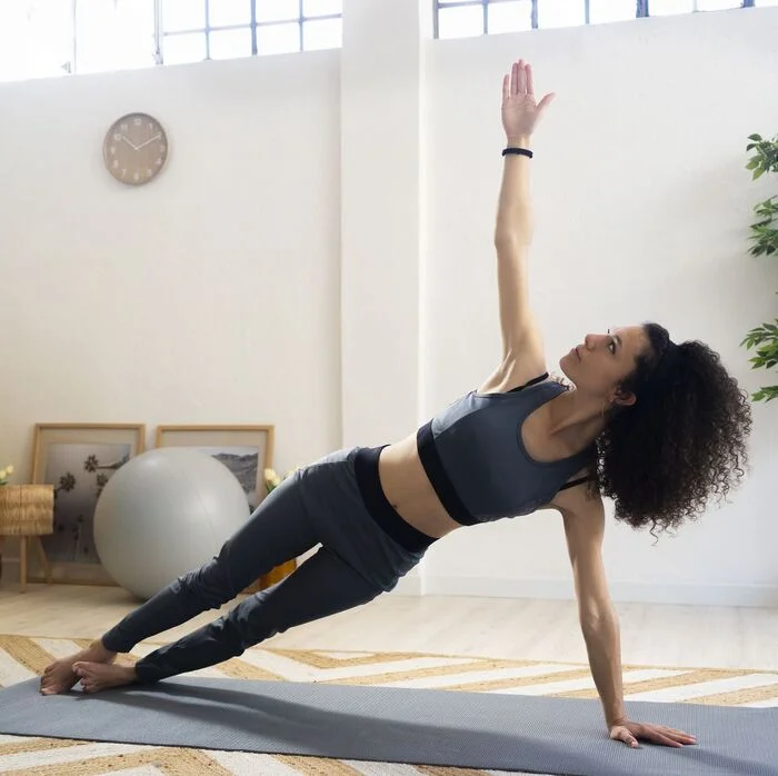 Mujer de lado sobre brazo haciendo pilates en Alicante