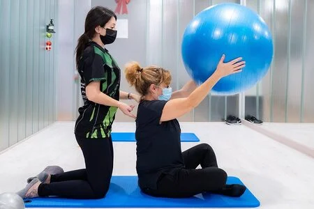 Mujer levantando pelota azul haciendo pilates de embarazada en Alicante